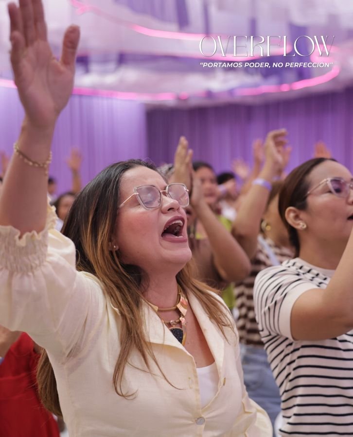 Mujeres con las manos levantadas cantando en Overflow